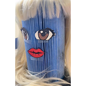 a Unicel filter with eyes, a mouth, and a wig on